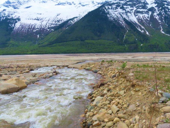 A photo of a stream with mountains in the background