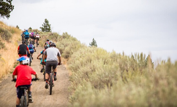 People mountain biking on a hillside trail