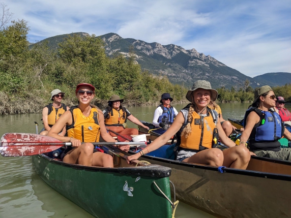A photo of people in canoes smiling for the camera