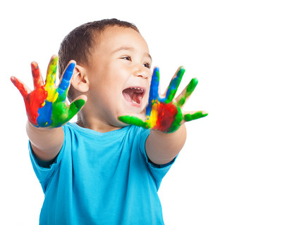 Child holding up hands covered in paint